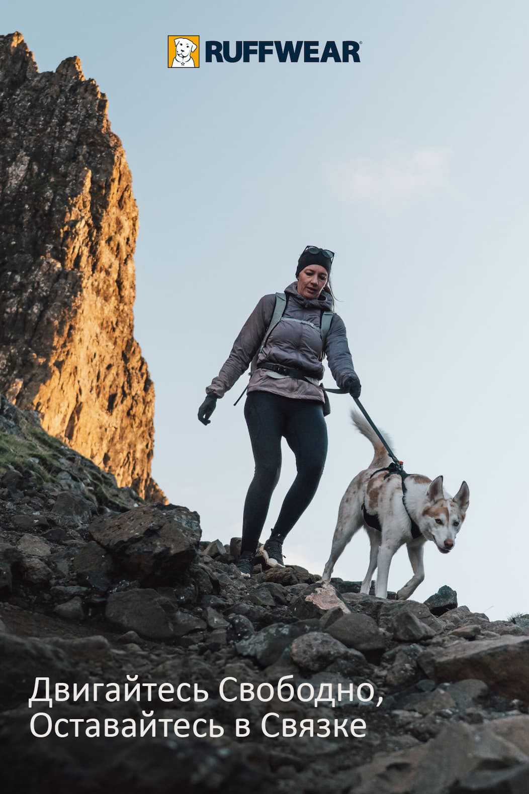 A human and dog scramble down the rocks together